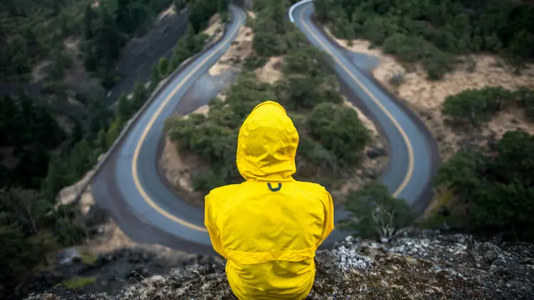 Mann in Outdoorkleidung blickt auf Kurve