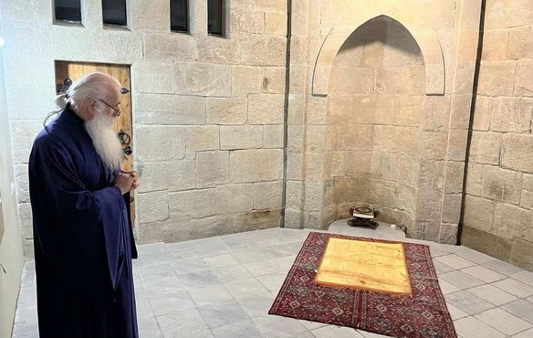 Metropolit Malkhaz Songulashvili (Ev. Baptisten Tiflis) zeigt den muslimischen Gebetsplatz hinter der Apsis der Kirche. 