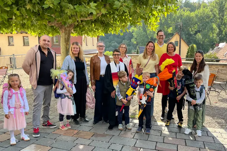 Oberkirchenrätin Carmen Rivuzumwami, Leiterin des Dezernats Bildung, Schule, Diakonat und Pfarrerin Barbara Martin mit Erstklässlerinnen und Erstklässlern und ihren Familien