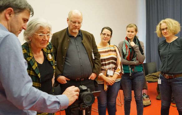 Pfarrer Thomas Ebinger (l.) erläutert die Kameraeinstellungen, die für das „Lightpainting“ nötig sind.