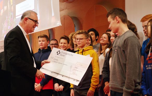 Landesbischof Dr. h.c. Frank Otfried July übergibt den Zehntklässlern aus Sachsenheim den Scheck über 1.000 Euro für die Klassenkasse: Ihre Plakatentwürfe haben die Jury am meisten überzeugt.