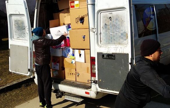 Männer beladen einen Transporter mit Hilfsgütern.